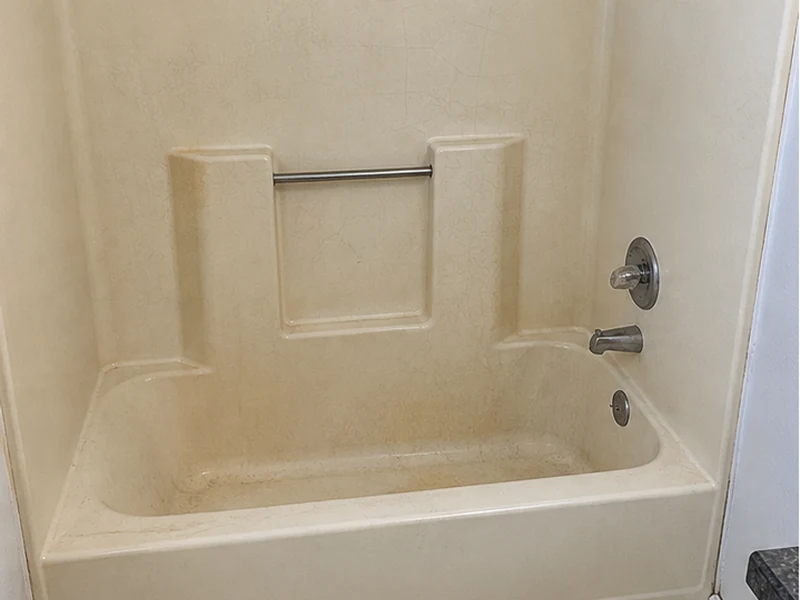 Faded crazed almond fiberglass tub-shower in a Cherryland apartment before refinishing, Hayward